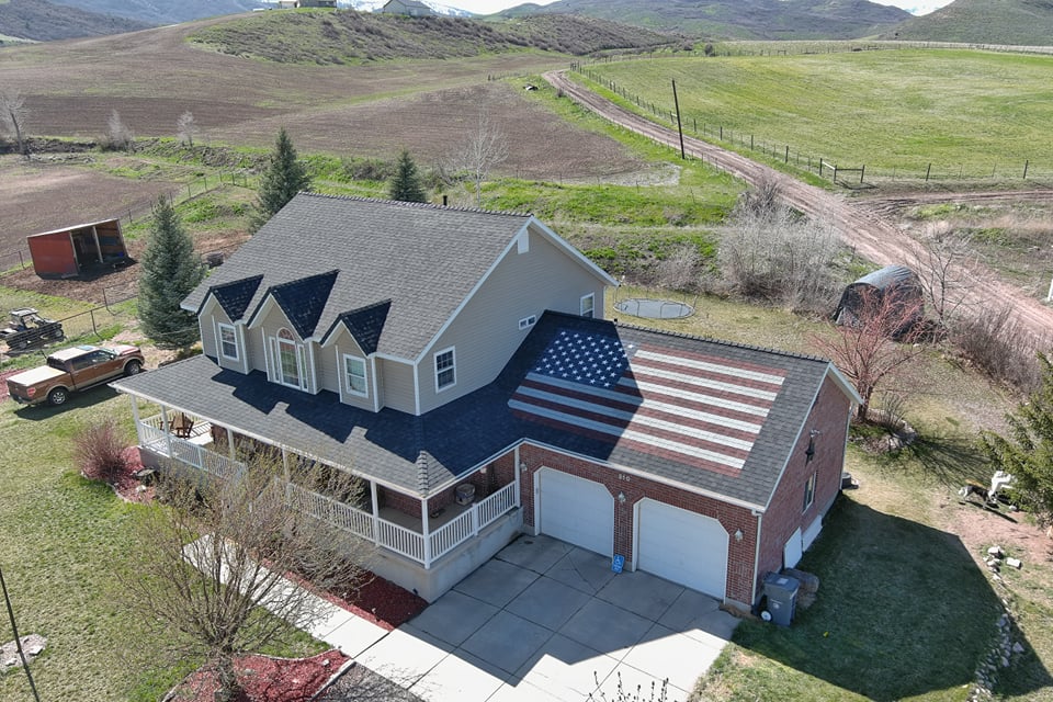 Two story home with american flag garage roof